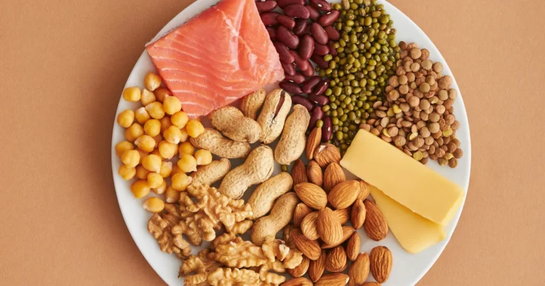 Assorted affordable protein foods including legumes, nuts, fish, and grains on a plate