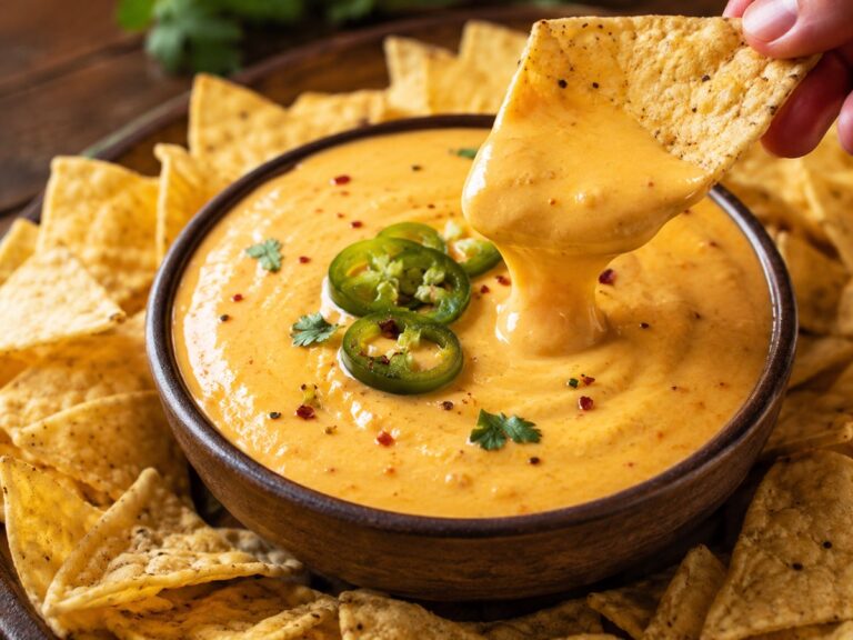 Creamy high-protein cottage cheese queso dip served warm in a small bowl with tortilla chips